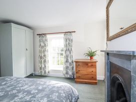 A bedroom with a wardrobe, chest of drawers, and window at Tresarrett Manor in Bodmin