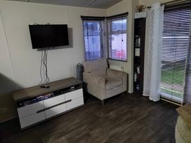 A living room with a television and an armchair at 237 - Penkalick in Padstow