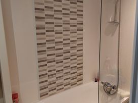 A bathroom with a bathtub and a tiled wall at 237 - Penkalick Padstow