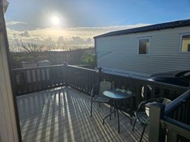 A deck with a table and chairs at 237 Haryn Sands Holiday Park in Padstow