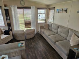 A living room with a sofa and a bookshelf at 237 Haryn Sands Holiday Park, Padstow