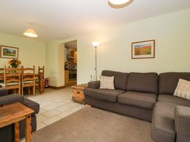 A living room with a sofa and dining area at Orchard Cottage in Corse near Gloucester