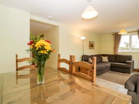 A dining room with a table and chairs and a sofa at Orchard Cottage Corse near Gloucester