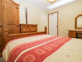 A bedroom with a bed, wardrobe, and chest of drawers at Orchard Cottage in Corse near Gloucester
