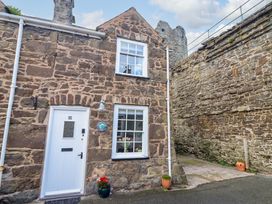 A stone cottage exterior with a front door and window at Periwinkle Cottage in Conwy