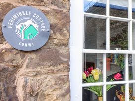 A sign and window at Periwinkle Cottage in Conwy