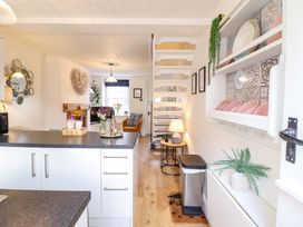 A kitchen with a staircase and a table at Periwinkle Cottage in Conwy