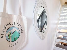 A hallway with a tote bag and a mirror at Periwinkle Cottage in Conwy