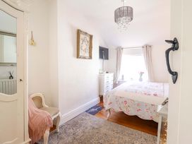 A bedroom with a bed and dresser at Periwinkle Cottage in Conwy