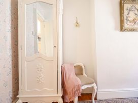 A wardrobe and small chair in a hallway at Periwinkle Cottage in Conwy