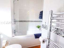 A bathroom with a bathtub and towels at Periwinkle Cottage in Conwy