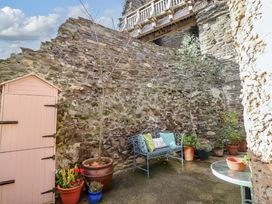 A garden with a stone wall and a bench at Periwinkle Cottage in Conwy