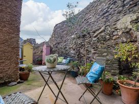 A garden with a table and chairs surrounded by plants at Periwinkle Cottage in Conwy