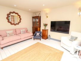 A living room with a pink sofa and TV at 52 Lee Road Aldeburgh