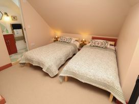 A bedroom with two beds and a bathroom area at 52 Lee Road Aldeburgh