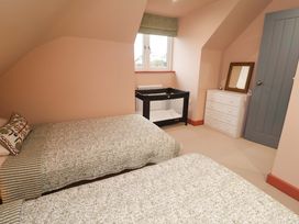 A bedroom with two beds and a crib at 52 Lee Road in Aldeburgh