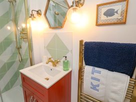 A bathroom with a sink, shower, and towels at 52 Lee Road in Aldeburgh