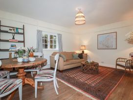 A living room with a sofa and dining table at Copper Mine Cottage in Bodmin