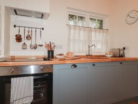 A kitchen with a sink and cooking appliances at Copper Mine Cottage, Bodmin