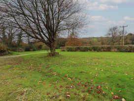 A garden with a tree and grass at Copper Mine Cottage in Bodmin