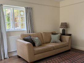 A living room with a sofa lamp and window at Copper Mine Cottage Trelill near Port Isaac