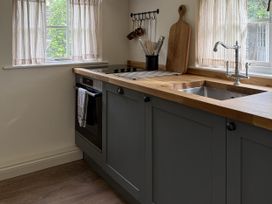 A kitchen with a sink and stove at Copper Mine Cottage Trelill near Port Isaac