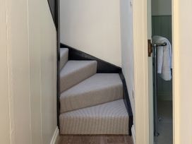 A staircase with carpet steps and a towel rail at Copper Mine Cottage in Trelill near Port Isaac