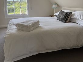 A bedroom with a bed and pillows at Copper Mine Cottage Trelill near Port Isaac