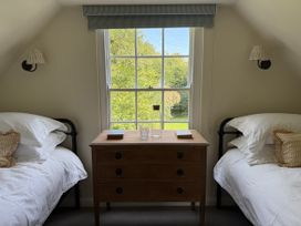 A bedroom with two beds and a chest of drawers at Copper Mine Cottage Trelill near Port Isaac