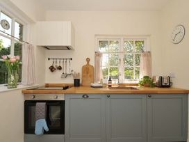 A kitchen with a sink, oven, and various utensils at Copper Mine Cottage, Trelill near Port Isaac