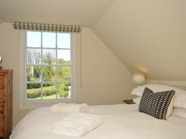 A bedroom with a window and bed at Copper Mine Cottage Trelill near Port Isaac