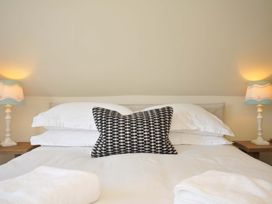 A bedroom with a bed and bedside lamps at Copper Mine Cottage in Trelill near Port Isaac