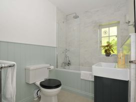 A bathroom with a bathtub and shower at Copper Mine Cottage in Trelill near Port Isaac
