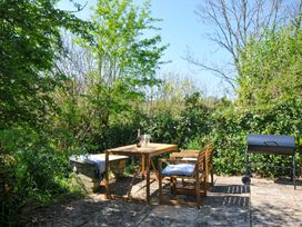An outdoor seating area with a table and chairs at Copper Mine Cottage Trelill near Port Isaac