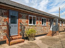 An exterior view of a building with steps and a planter at The Milk Shed Plymtree