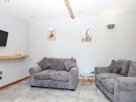 A living room with two sofas and a TV at The Milk Shed in Plymtree
