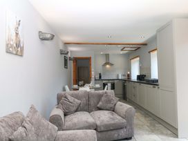A living room with a sofa and kitchen area at The Milk Shed in Plymtree