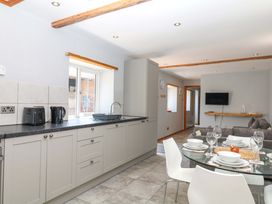 A kitchen with a dining table and chairs at The Milk Shed in Plymtree