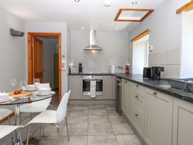 A kitchen with stove and dining table at The Milk Shed in Plymtree