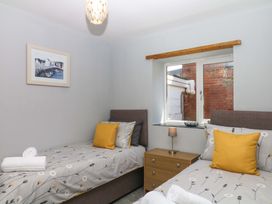 A bedroom with twin beds and a bedside table at The Milk Shed Plymtree