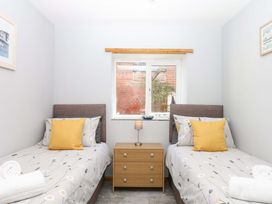 A bedroom with two beds and a nightstand at The Milk Shed in Plymtree
