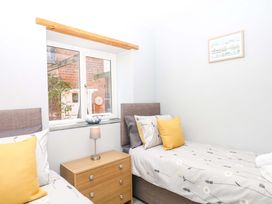 A bedroom with two beds and a window at The Milk Shed Plymtree