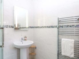 A bathroom with sink, mirror and towel rail at The Milk Shed in Plymtree