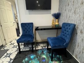 A living room with two chairs and a console table at The Old Barn in Manchester