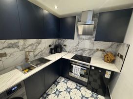 A kitchen with a sink, cooker and fridge at the property in location