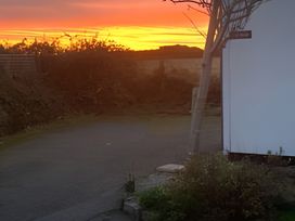 A view of a sunset with a tree and road at The Nook in 