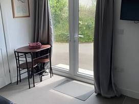 A snug room with a table and window at The Nook in 