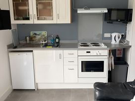 A kitchen with a countertop, sink, stove, oven, refrigerator and microwave at The Nook