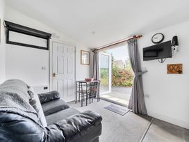 A living room with a sofa, table, and chair at The Nook in Praa Sands