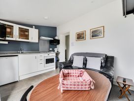A living room with a kitchen unit and sofa at The Nook in Praa Sands